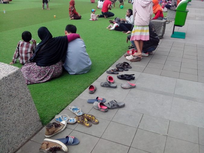 Alas Kaki Pengunjung yang Disimpan di Sisi Rumput Sintetis